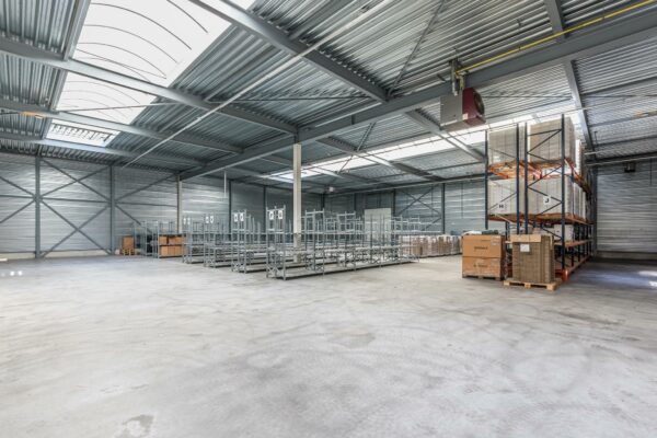 Ruim en licht industriepand aan de Laan Blussé van Oud-Alblas met stellingen en opgeslagen dozen.